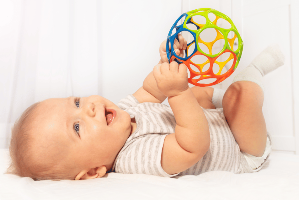 Piłka Oball jako zabawka zachęcają co łączenie dłoni oraz rozwój linii środkowej ciała. Zabawki wspierające rozwój dla niemowląt Fizjo z Głową, Kamil Hernoga